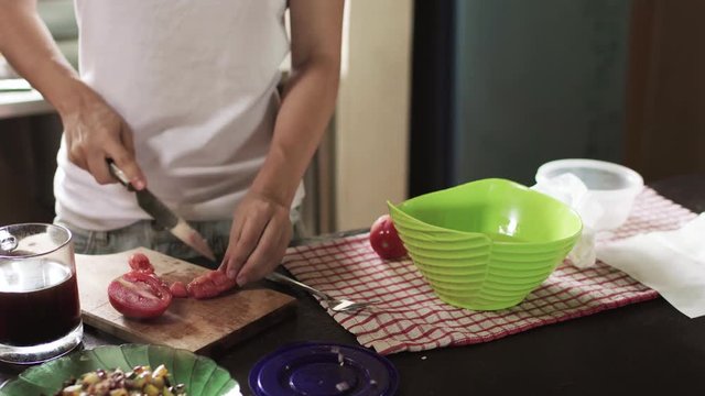 Girl chopping tomato on kitchen