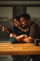 Man showing something trough window to his laughing girlfriend