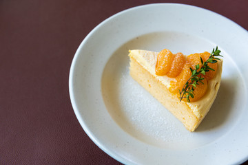 orange cake with orange fruit topping on white dish