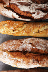 Assortment of baked bread and bread rolls on stone table background