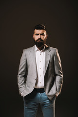 Obraz premium beard businessman posing in gray jacket isolated on brown
