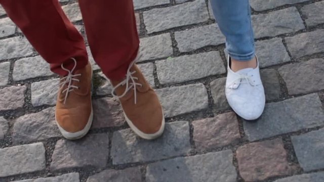 feet of two people go on the road of stones
