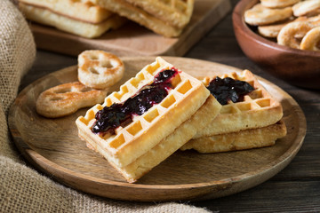 Waffles on a wooden plate on a wooden table. Rustic style
