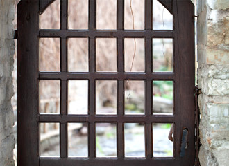 Wooden latticed door closes the entrance to the courtyard. Shallow depth of focus