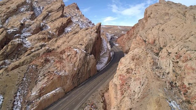 Flying backwards over road cutting into canyon gorge in Utah on I-70 in the San Rafael Swell.