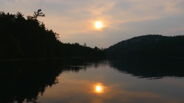 Mirrored reflection of sunset on OSA lake in Killarney provincial park in Ontario, Canada.