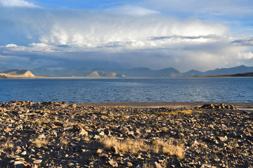 China. Great lakes of Tibet. Big cloud over Lake Teri Tashi Namtso in the setting sun in summer