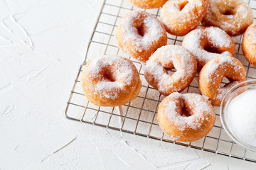 Homemade Donuts With Powdered Sugar On A Cooling Tray