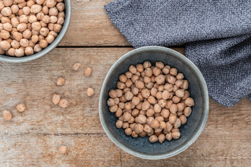 Schüsseln mit getrocknete Kichererbsen auf einem alten Holzhintergrund