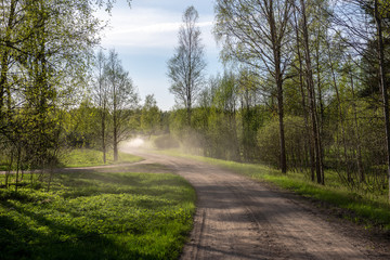 empty country gravel road with mud puddles and bumps