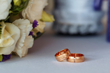 wedding rings on a bouquet of white roses