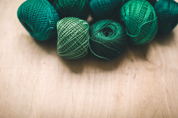 bright green sewing thread on a light wooden background