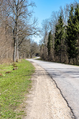 empty country gravel road with mud puddles and bumps