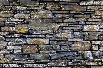 stone wall fragment, flat size stones of different sizes, thickness, width making a beautiful structure in different colors