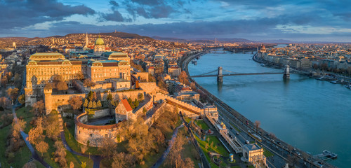 Budapest, Hungary - Aerial panoramic view of Buda Castle Royal Palace with Szechenyi Chain Bridge, Parliament and colorful clouds at sunrise