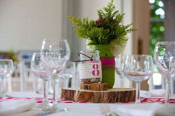 Green and pink rustic bouquet of flowers on a block of wood during a wedding celebration 