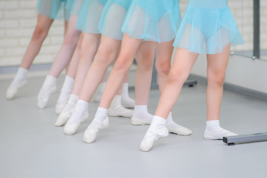 Ballet school. Little girls students practicing near barre work for feet positions .Closeup detail shot of feets in pointe shoes.