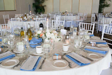 Wedding table decoration series - tables set for beautiful indoor catered luxury wedding event with blue napkins 