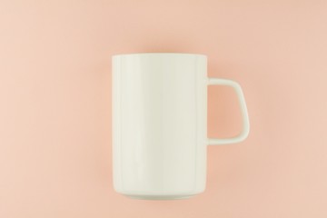 white ceramic coffee cup on pink background.