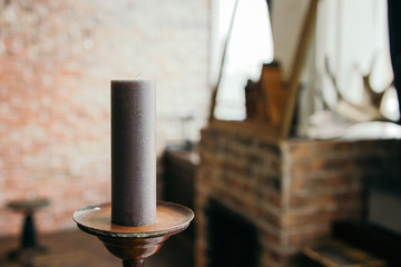 A dark candle stands in a candlestick. space for text