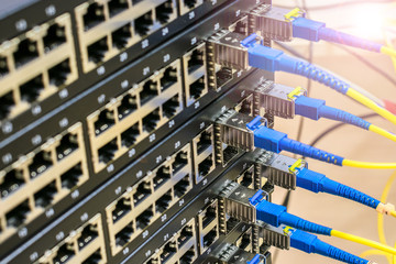 Server equipment of the main technical platform.  A stack of managed Internet switches is connected by fiber optic cables.  The concept of high-speed data and information transmission.