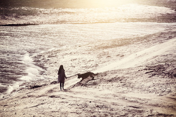 Fototapeta na wymiar young woman with his dog walking near the lake, abstract nostalgic vintage tonning
