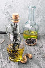 oil jugs with olive oil and black garlic in rustic gray setting