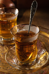 Turkish apple tea or Elma Cayi a fruit flavoured beverage served in Turkish glasses lit with creative lighting