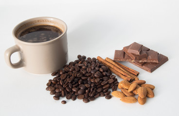 Cup of coffee, coffee beans, nuts, chocolate and spices