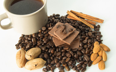 Cup of coffee, coffee beans, nuts, chocolate and spices