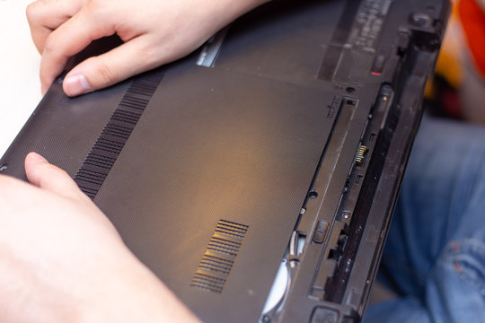 young man hands repare laptop at home