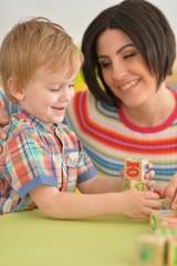 Naklejka premium Portrait of young mother playing with son