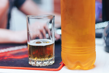 beer in glass and plastic bottle on table man beahind at home