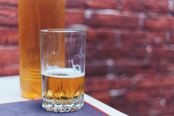 beer in glass and plastic bottle on table man beahind at home