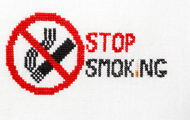 Stop smoking Sign of a stop of a cigarette embroidered on a white fabric.