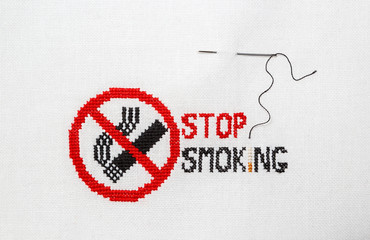 Stop smoking Sign of a stop of a cigarette embroidered on a white fabric.