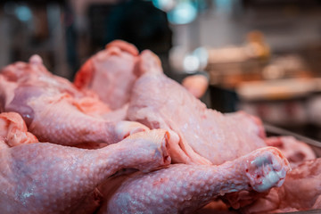 Raw chicken chops stacked and ready for preparation. Restaurant life, industrial food chain, uncooked proteins, close up of wings and breasts on a stainless steel tray