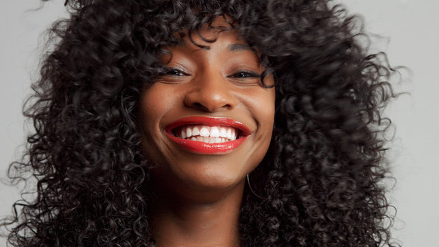 black woman wide smiling with lips with red lipstick