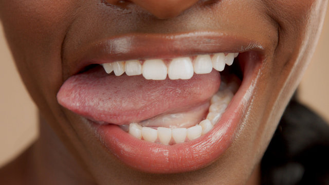 closeup shoot of black womans mouth with tongue out