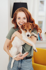 Excited young woman clutching her pet terrier
