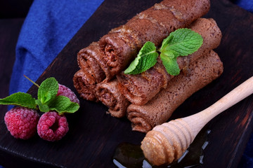 Chocolate rolled crepes topped with honey and mint