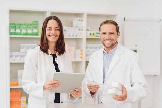 Two happy friendly pharmacists in a pharmacy