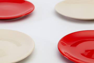 Red plates on the white wooden table.Top view.
