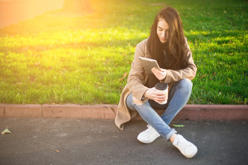Obraz premium young trendy woman in autumn city park with smartphone in hand