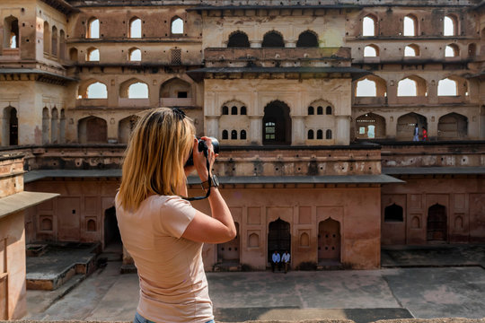 Young woman takes picture of Jahangir Mahal in Orchha, India