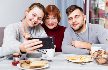 Young couple making selfie with senior woman