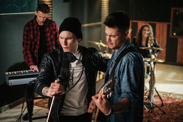 Music band having rehearsal in a studio