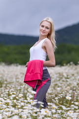 Portrait of slim girl in sportswear at chamomile field