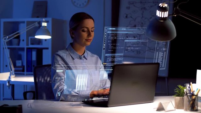 business, deadline and technology concept - businesswoman with laptop computer and virtual screen projection working at dark night office
