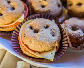small and delicious sandwiches of dark bread with ham and cheese